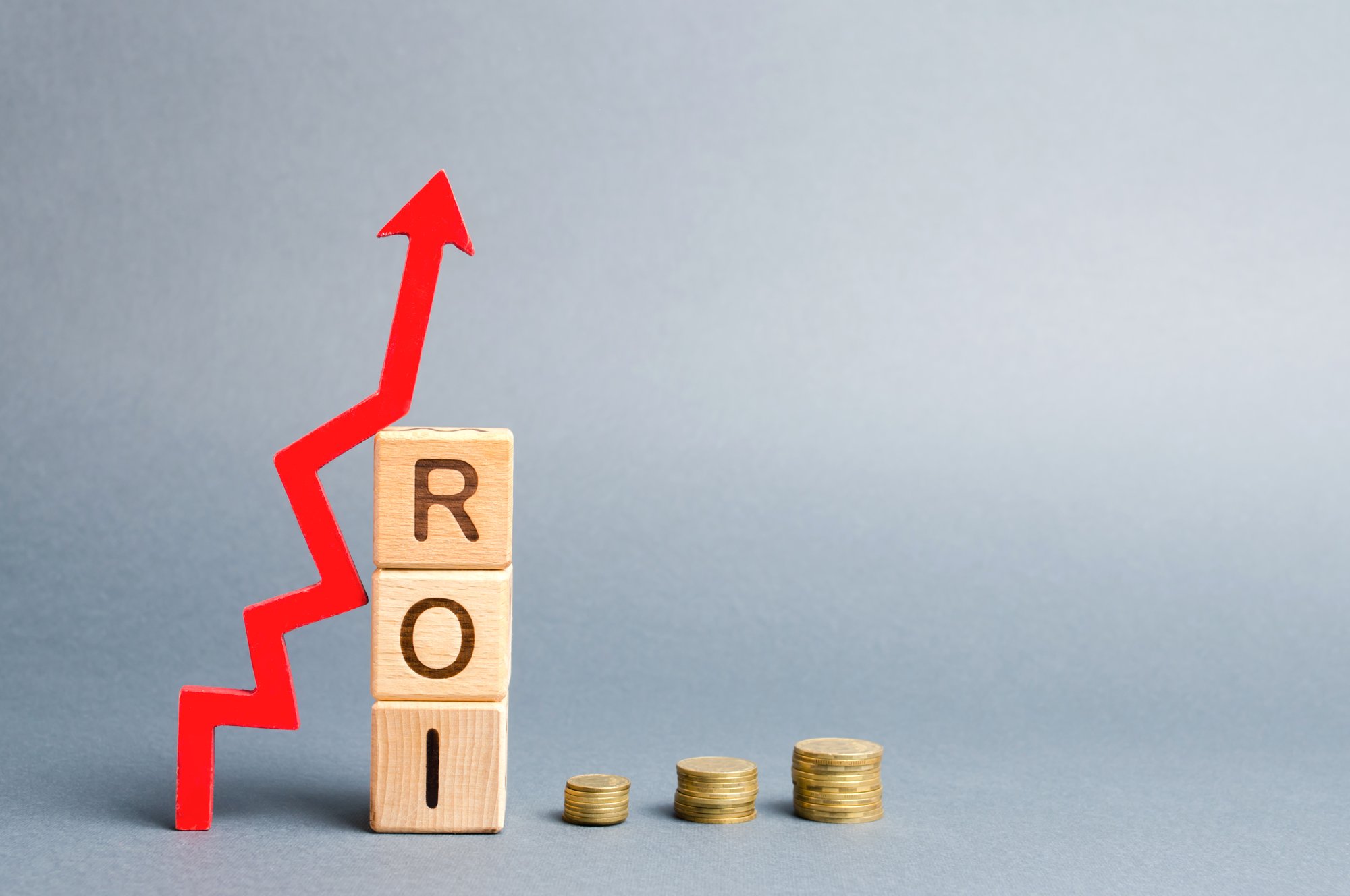 wooden-blocks-with-word-roi-arrow-up-high-level-business-profitability